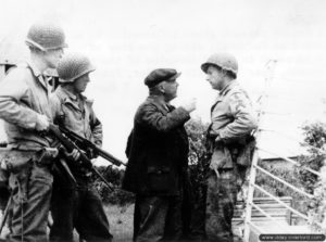 7 juin 1944 : le maire de Vierville Fernand Leterrier renseigne un caporal de la 29ème division d'infanterie. Photo : US National Archives