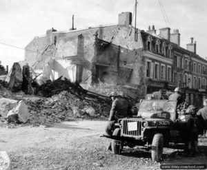 4 juillet 1944 : une Jeep Willys appartenant à la compagnie B du 509th Military Police Battalion sur la place Gambetta à Isigny-sur-Mer. Photo : US National Archives