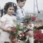 Deux jeunes normands déposent des fleurs à l'occasion du 14 juillet 1944 à Courseulles-sur-Mer. Photo : Archives Canada