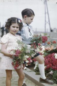 Deux jeunes normands déposent des fleurs à l'occasion du 14 juillet 1944 à Courseulles-sur-Mer. Photo : Archives Canada