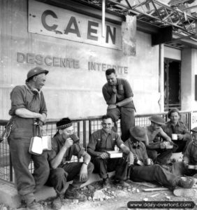 Pause repas sur le quai de la gare de Caen pour ces hommes de la 3ème division d’infanterie canadienne. Photo : US National Archives