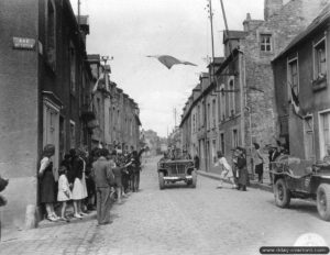 Juillet 1944 : la population de Carentan salue le passage de soldats américains dans les rues de la commune. Photo : US National Archives
