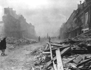 9 juin 1944 : des éléments du 1er bataillon du 175ème régiment de la 29ème division d’infanterie américaine entrent dans les ruines d’Isigny-sur-Mer. Photo : US National Archives