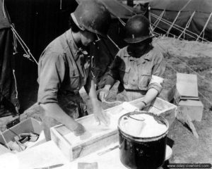 31 juillet 1944 : deux infirmières préparent des bandes de plâtres à l’hôpital de campagne de Saint-Hilaire-Petitville. Photo : US National Archives
