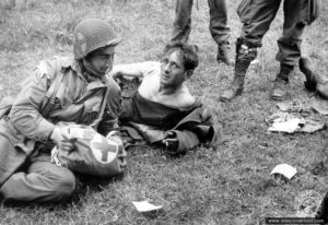 Le caporal Al Langdon, prend en charge un blessé allemand dans le secteur de Sainte-Mère-Eglise. Photo : US National Archives