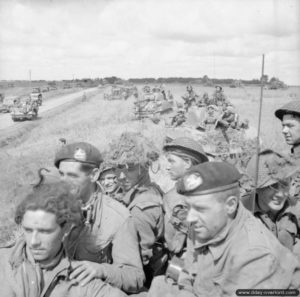 21 août 1944 : des soldats du 3rd Monmouthshire Regiment sur des chars Sherman du 2nd Fife and Forfar Yeomanry attendent l’ordre de progression dans le secteur d’Argentan. Photo : IWM