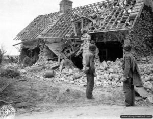 Deux parachutistes de la 101st Airborne Division inspectent une maison en ruine dans le secteur de Carentan. Photo : US National Archives