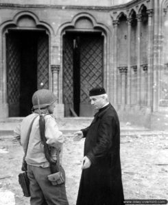 Le chanoine Lepoil et un capitaine français intégré à l’armée américaine discutent devant la cathédrale Notre-Dame de Coutances. Photo : US National Archives