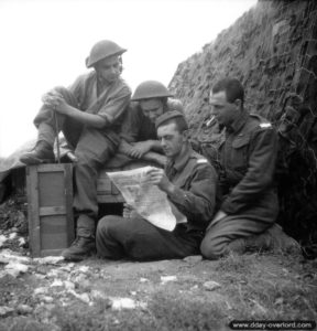 Près de leur abri, les soldats canadiens Fred Morriss, Ed Lacey, Maurice Luftspring et George Mutcheon lisent le journal The Maple Leaf (La Feuille d’érable) distribué sur le front dans le secteur d'Ifs. Photo : US National Archives