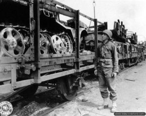 Un soldat américain contrôle des wagons chargés de véhicules SdKfz 10.4. Photo : US National Archives