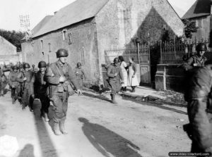 Des soldats américains de la 2ème division d'infanterie traversent Colleville-sur-Mer. Photo : US National Archives