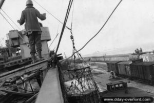 Déchargement de caisses de munitions dans un filet de manutention sur la digue du Homet à Cherbourg. Photo : US National Archives