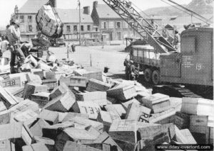 Déchargement de caisses en bois à l'aide d'une grue au port de Cherbourg. Photo : US National Archives