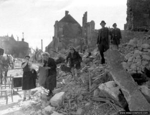 Des habitants d’Isigny recherchent leurs affaires dans les décombres des maisons. Photo : US National Archives