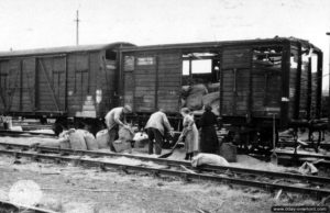 Récupération de grains de céréales dont les sacs ont été endommagés par les bombardements de la gare de Lison. Photo : US National Archives