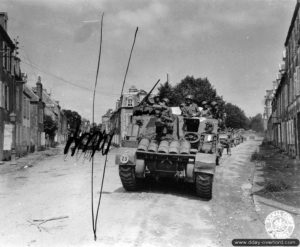 Des soldats du 357ème régiment de la 90ème division d’infanterie accompagnée par des chars du 4th Armored à Coutances. Photo : US National Archives