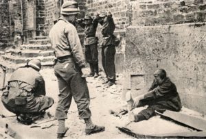 9 juillet 1944 : des prisonniers allemands sont rassemblés devant l’église de La-Haye-du-Puits par des soldats appartenant au 121ème régiment de la 8ème division d’infanterie américaine. Photo : US National Archives