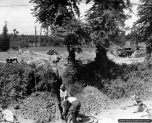 Mise en place des canalisations à travers une haie au profit de l’hôpital de campagne de Saint-Hilaire-Petitville. Photo : US National Archives