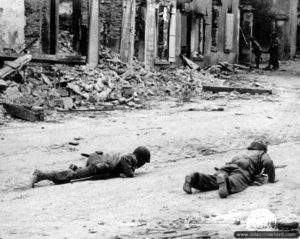 20 juillet 1944 : des soldats de la 29ème division d’infanterie se plaquent au sol pour échapper aux tirs d’un sniper allemand à Saint-Lô. Photo : US National Archives