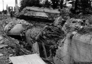 Les ruines du bunker type Regelbau R618 du point d’appui Wn 544 utilisé par la 709ème division d’infanterie allemande comme centre de transmissions à Valognes. Photo : US National Archives