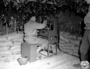 19 juin 1944 : au sud de Grandcamp-les-Bains, près du Hameau Poix, des soldats américains chargés d'installer des moyens de communication, mettent en oeuvre un standard téléphonique dans un abri récupéré aux Allemands. Photo : US National Archives