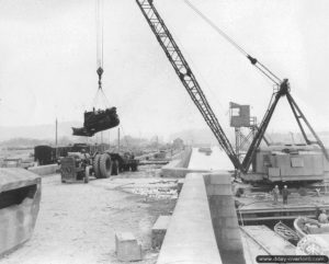 Une grue soulève un Caterpillar D7 à Cherbourg. Photo : US National Archives