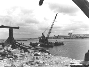 Une grue à flèche relève des épaves dans la rade de Cherbourg. Photo : US National Archives