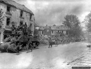Des soldats du 357ème régiment de la 90ème division d’infanterie accompagnée par des chars du 4th Armored à Coutances. Photo : US National Archives
