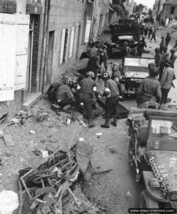 26 juillet 1944 : des infirmiers prennent en charge les occupants d’une Jeep qui a sauté sur une mine allemande avenue du maréchal Pétain à Coutances. Photo : US National Archives