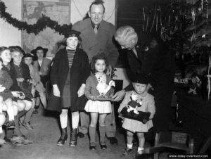 24 décembre 1944 : le Major John Moe, remet à des enfants de Cherbourg des jouets confectionnés par le 757th R. shop Batallion pour les fêtes de Noël. Photo : US National Archives