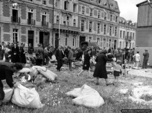 Sur la place Napoléon à Cherbourg, des civils récupèrent ce qui peut encore l’être. Photo : US National Archives