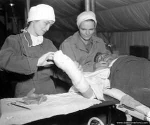 Prise en charge d’un blessé par deux infirmières américaines dans le secteur de Carentan. Photo : US National Archives