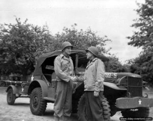 Le Major General H. S. Sayler serre la main du Colonel B. Masik : le véhicule 4X4 Dodge WC 56 derrière eux a débarqué à Cherbourg en pièces détachées un lundi à 3 heures du matin et était assemblé et prêt au combat à midi le jour suivant. Photo : US National Archives