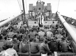 Un aumônier célèbre une messe à bord d'un transporteur de troupes lors de la traversée de la Manche. Photo : US National Archives