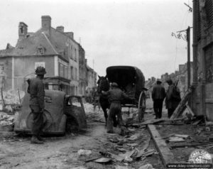 La rue Paul Lecacheux à Montebourg, avec notamment une épave de Simca 8. Photo : US National Archives