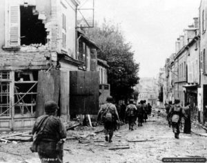 Des soldats du 39ème régiment de la 9ème division d’infanterie dans la rue du Président Loubet à Cherbourg. Photo : US National Archives