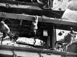 June 6, 1944: the body of an LCVP helmsman is evacuated aboard a coastguard building off Omaha Beach. Photo: US National Archives