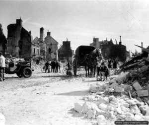 Les habitants d’Isigny-sur-Mer au milieu des ruines de la place Gambetta. Photo : US National Archives