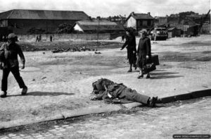 Des civils normands à proximité d’un cadavre allemand à Cherbourg. Photo : US National Archives