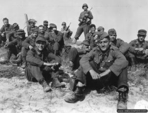 15 juin 1944 : des prisonniers allemands attendent à Utah Beach d'embarquer vers l'Angleterre. Photo : US National Archives