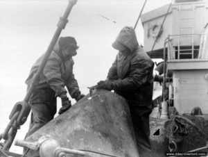 Relève d’un filet métallique anti-sous-marins allemand à bord de l’USS Pinon à Cherbourg. Photo : US National Archives