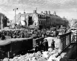 Des troupes américaines sont saluées par la population d’Isigny sur la place Gambetta. Photo : US National Archives