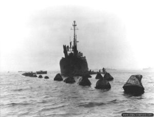 L’USS Pinon chargé de relever un filet métallique anti-sous-marins allemand à Cherbourg. Photo : US National Archives