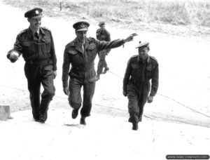 De gauche à droite : le colonel Malone, le général Crerar et le Major Austin à l'état-major de la 1ère armée canadienne installé dans le château de Rots. Photo : US National Archives