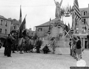 Dépôt de gerbes sur la Place de la République à Carentan en l’honneur de la fête nationale française le 14 juillet 1944. Photo : US National Archives