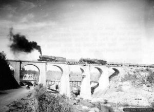 Une locomotive 140 traverse le viaduc de la ligne de chemin de fer Caen-Lamballe sur la Soulle, grâce à la mise en place d'un élément Bailey, dans le secteur de Coutances. Photo : US National Archives