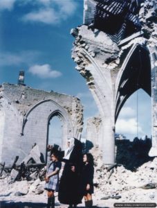 Une religieuse et deux jeunes filles de Valognes devant les ruines de l’église Saint-Malo de Valognes. Photo : US National Archives