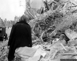 Les soldats Roy Wilson et James Janon déblaient les ruines avec des habitants de Valognes. Photo : US National Archives