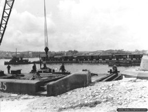 26 juillet 1944 : une rame de wagons sur une barge tractée par un remorqueur à Cherbourg. Photo : US National Archives