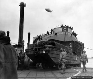 16 juin 1944 : le LST 543 et la remorque ST 760 accoste le ponton Whale et débarque sa précieuse cargaison. Ici, un véhicule amphibie DUKW. Photo : US National Archives
